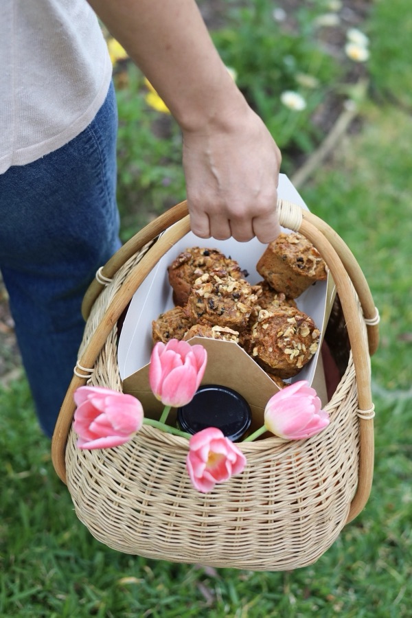 A basket of muffins and tulips being carried to a new mama